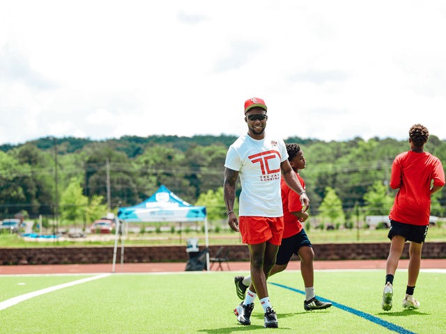 Tre' Rogers walking with young athletes