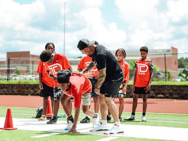 Coach working with young athletes on stance and start technique