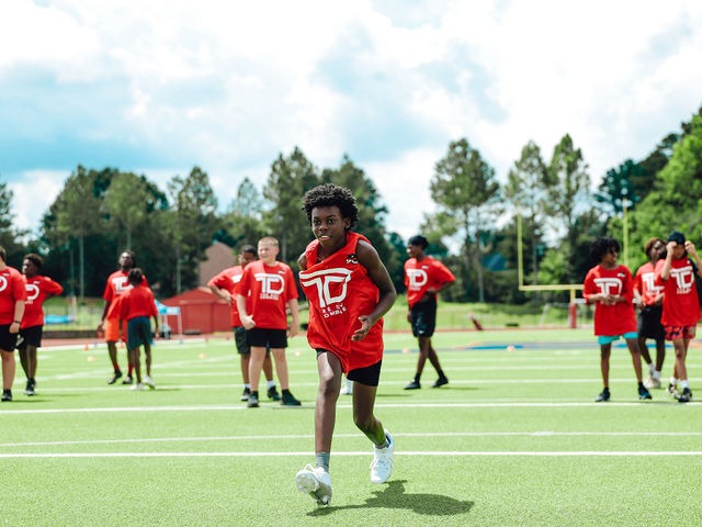 Young athlete sprinting in a Tre' Day Combine jersey on the turf